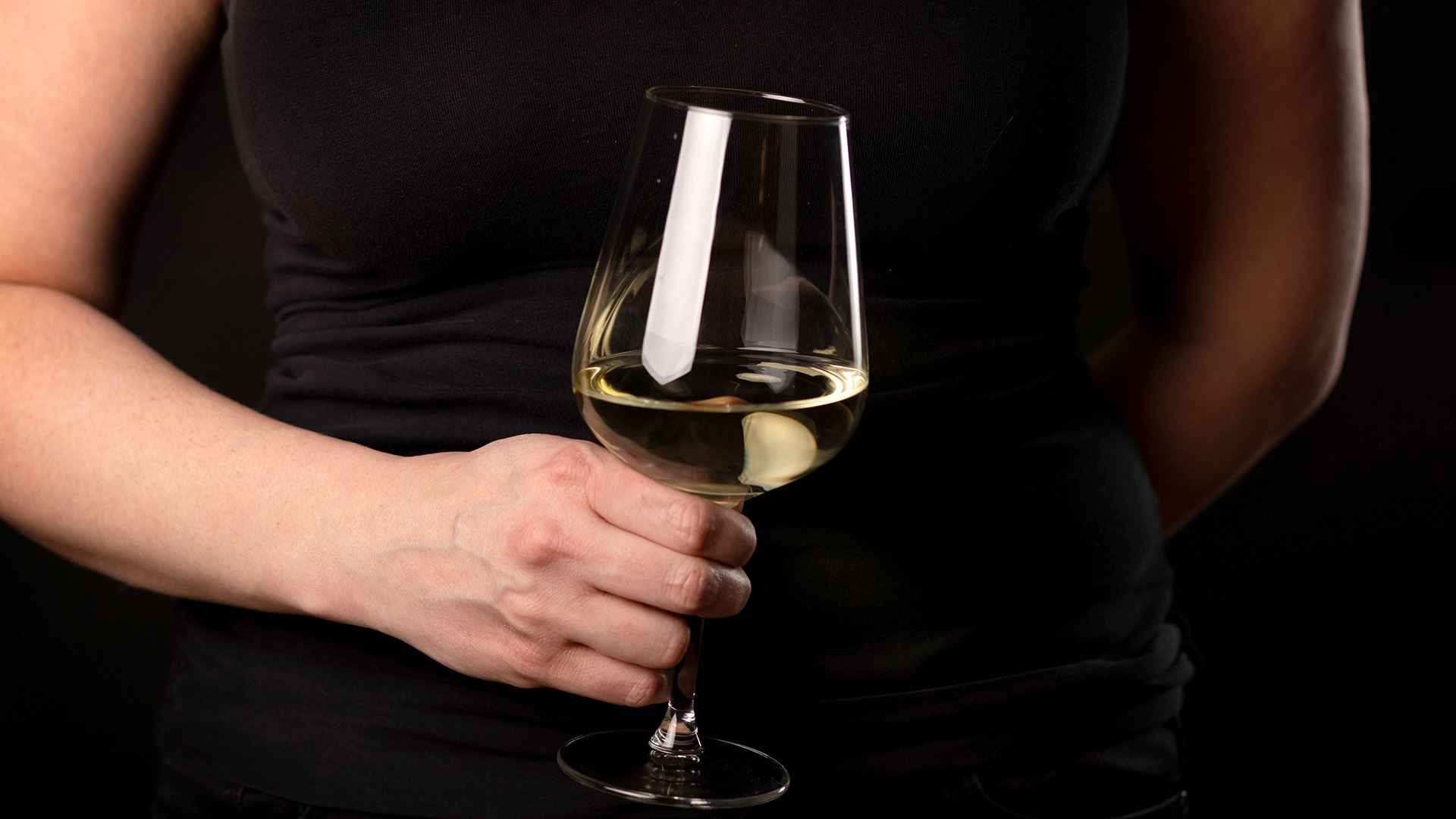 Eine Frau hält ein Glas mit Weißwein in der Hand. | picture alliance / Andreas Frank